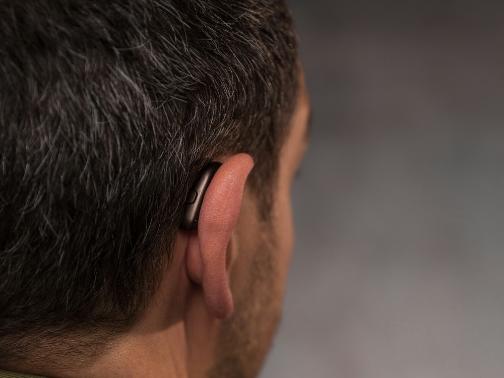 Hearing instrument specialist programming a new hearing aid during a fitting at Contra Costa Hearing Aid Center in Walnut Creek, CA