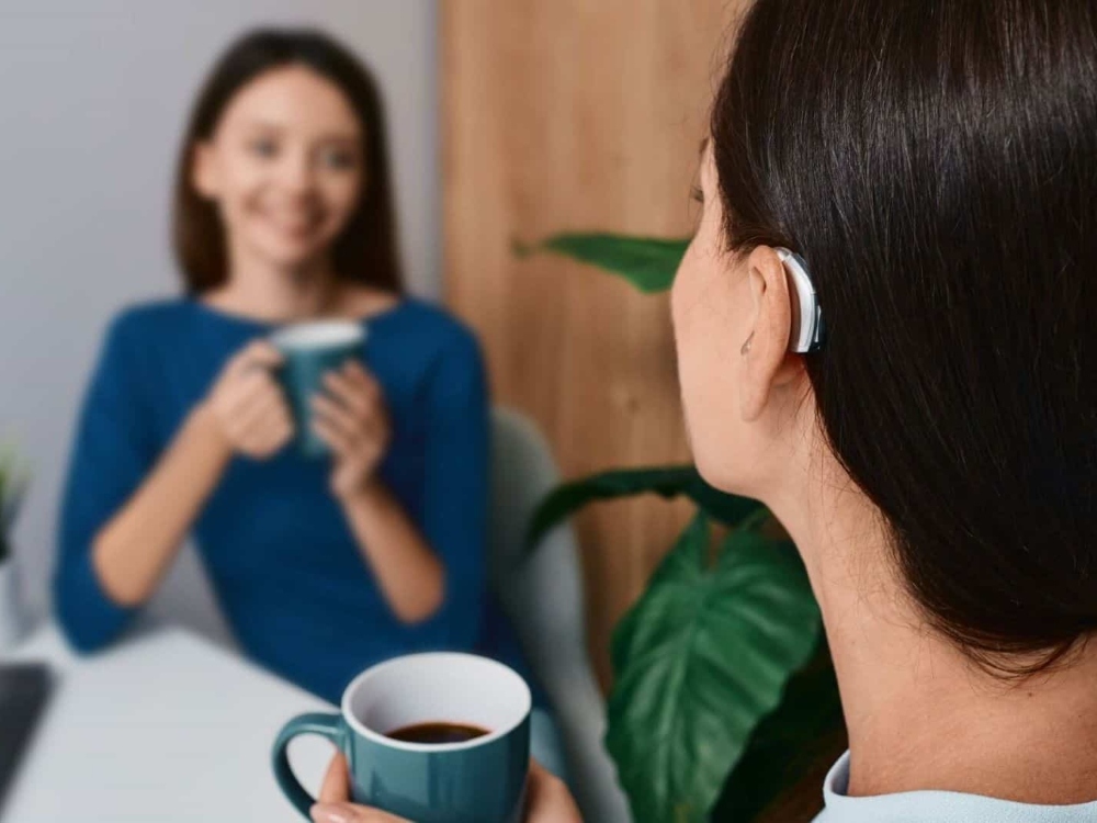 Woman wearing a receiver-in-canal hearing aid, one of several hearing aid styles fit at Contra Costa Hearing Aid Center in Walnut Creek, CA