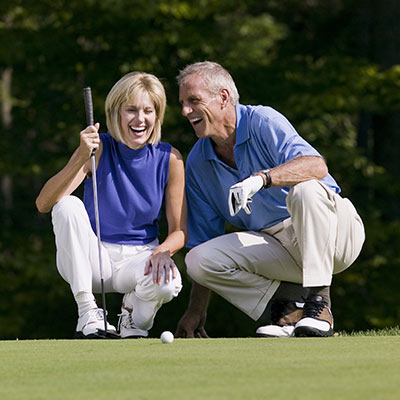 Active middle-age couple golfing