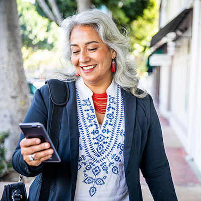 Woman wearing a hearing aid that syncs with her smartphone